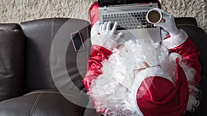 Top-down angle of Santa Claus sitting in sofa at home using wire