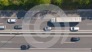 TOP DOWN: Big white truck drives along the freeway during a light traffic jam.