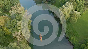 TOP DOWN: Carefree tourists paddle their canoe along the tranquil river Krka.