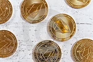Top down detailed view, golden commemorative EOS - EOSIO  cryptocurrency - coins on white stone board photo