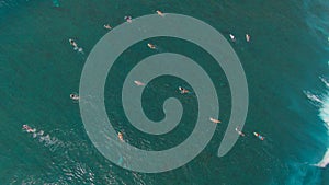 TOP DOWN: Massive barrel wave crashes and splashes over surfers paddling out.