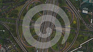 Top down overhead aerial view of busy car traffic on a modern large multi lane intersection on a highway