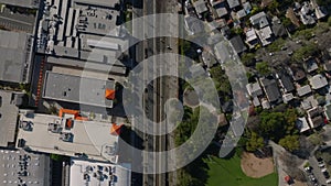 Top down panning footage of street and railway tracks leading through urban borough. Los Angeles, California, USA