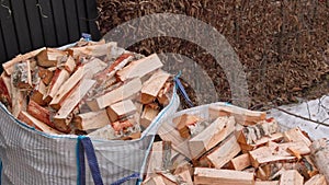 Top-down perspective of birch firewood delivered in transport bags on a spring day.