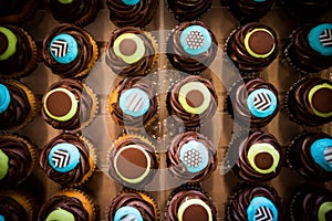 Top down shot of colorful blue and yellow chocolate cupcakes.