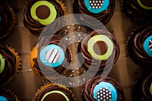 Top down shot of colorful blue and yellow chocolate cupcakes.