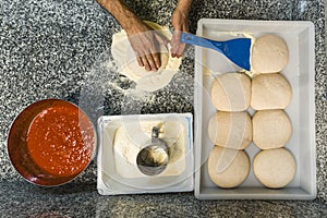 top down shot of man preparing pizza in the kitchen, italian cuisine concept