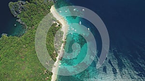 Top down tropic green island at sea bay aerial view. Sail boats on water at Philippines harbor, Asia