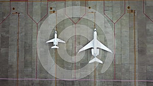 Top down view of airplanes parked on airport. Aerial view of parked airplanes at the airport runway. Situation due to