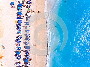 Top down view of a beach with tourists suntbeds and umbrellas wi