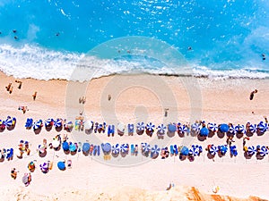 Top down view of a beach with tourists suntbeds and umbrellas wi