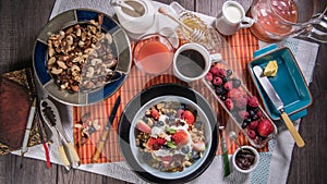 Top down view of a breakfast of yogurt, cereals, berries and dry fruits