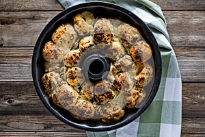 Top down view of a bundt pan filled with freshly baked pull apart rolls ready for eating. Also known as monkey bread.