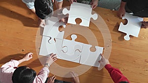 Top down view of business people assemble jigsaw puzzle on table. Convocation.