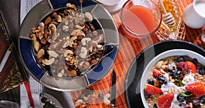 Top down view of cereals with berries, dry fruits and cream