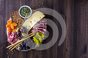 Top down view of a Charcuterie board filled with various finger foods.