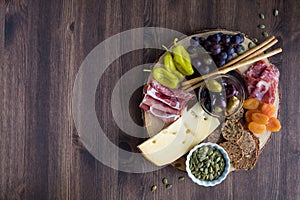 A Top down view of a charcuterie board filled with various healthy finger foods.