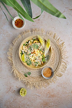 Top down view of a delicious vegan Bali style pomelo salad on a place mat, bamboo leaf