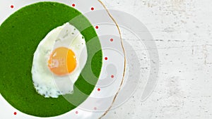 Top down view, detail of plate with cooked spinach and fried egg, on stone board - space left on right side