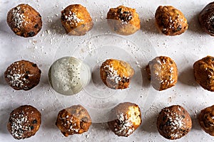 Top down view of Dutch traditional oliebollen with powdered sugar on white background, horizontal