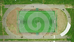 Top-down view of the football field. Children play football in a provincial town. Aerial drone 4K footage