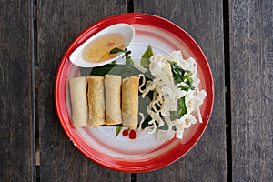 Top down view of four Thai springrolls on a traditional plate