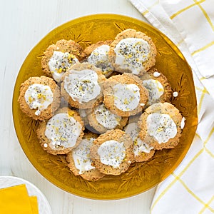 Top down view of a golden glass plate of homemade lemon poppyseed cookies.