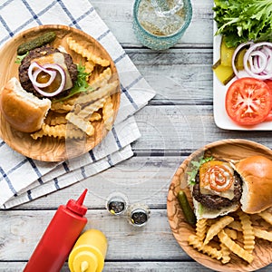 Top down view of hamburger sliders on small plates served with french fries.