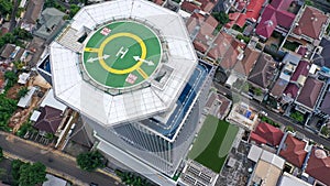 Top down view of helicopter landing pad on the roof of modern skyscraper in Jakarta city