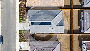 Top Down view of a house with a solar panel on it and a empty backyard