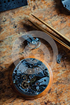 Top down view of an old watch mechanism on a workbench