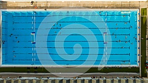 Top down view of public swimming pool. Water polo team practicing. Artistic swimming practicing