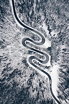 Top down view of a road in the middle of the forest in winter season