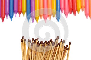 Top down view of a row of colorful candles and a row of matchsticks
