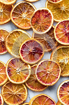 Top down view of several dried spiced orange slices against a light background.