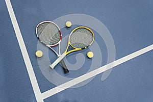 Top down view of a tennis racket, balls and the white line on a cyan tennis court. tennis sports concept