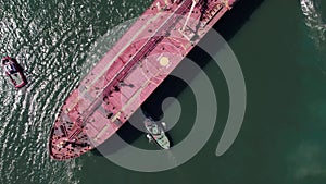 Top down view of Tug boats assisting big cargo ship.