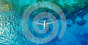 Top down view of white plane flying over blue sea, ocean, travel, vacation concept - AI generated image