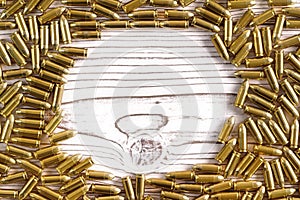 Top down view, yellow brass ammo bullets on wooden boards - scattered in frame, space for text at middle