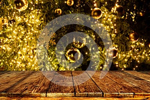 Top of empty wood table with beautiful Christmas tree and lights backdrop.
