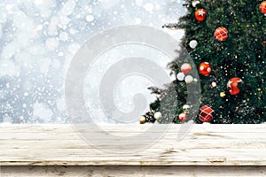 Top of empty wood table with beautiful Christmas tree and snowfall