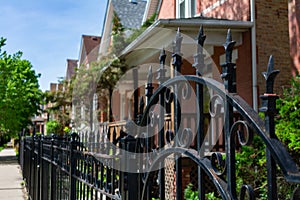 Top of a Fancy Black Metal Fence in front of a Row of Old Homes in Logan Square Chicago