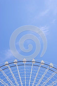 Top of ferris wheel in white color against summer blue sky
