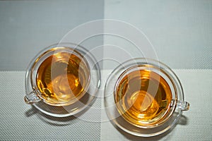 Top flat lay of two cups of tea kept in glass cup and saucer