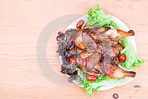 Top flat view on juicy grilled roast chicken with herb, salad and tomato garnish