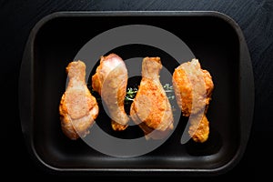 Top flat view of roasted chicken legs on the black background