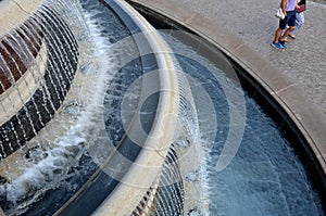 At the top of the fountain in the city, a pigeon is standing in the