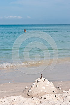 Sand castle with shells for window on a tropical beach