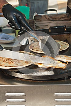 Greek vender grilling chicken and flatbread at a tropical farmers market photo