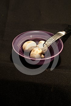 Purple, ceramic bowl with three white mushrooms